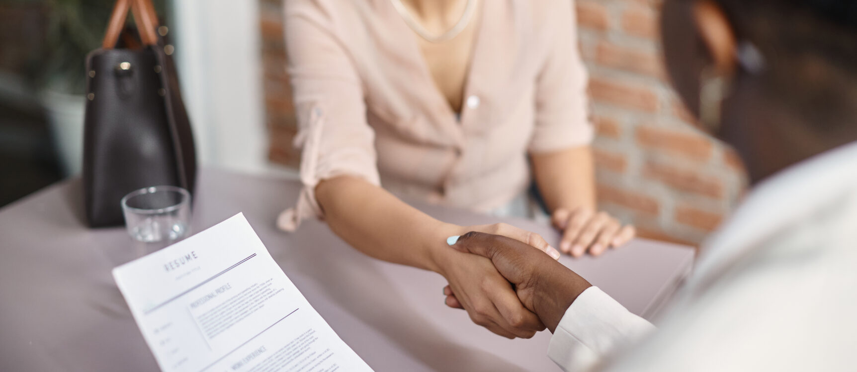 Job Fair - Close-up of member of human resource team greeting job applicant during a meeting in the office.