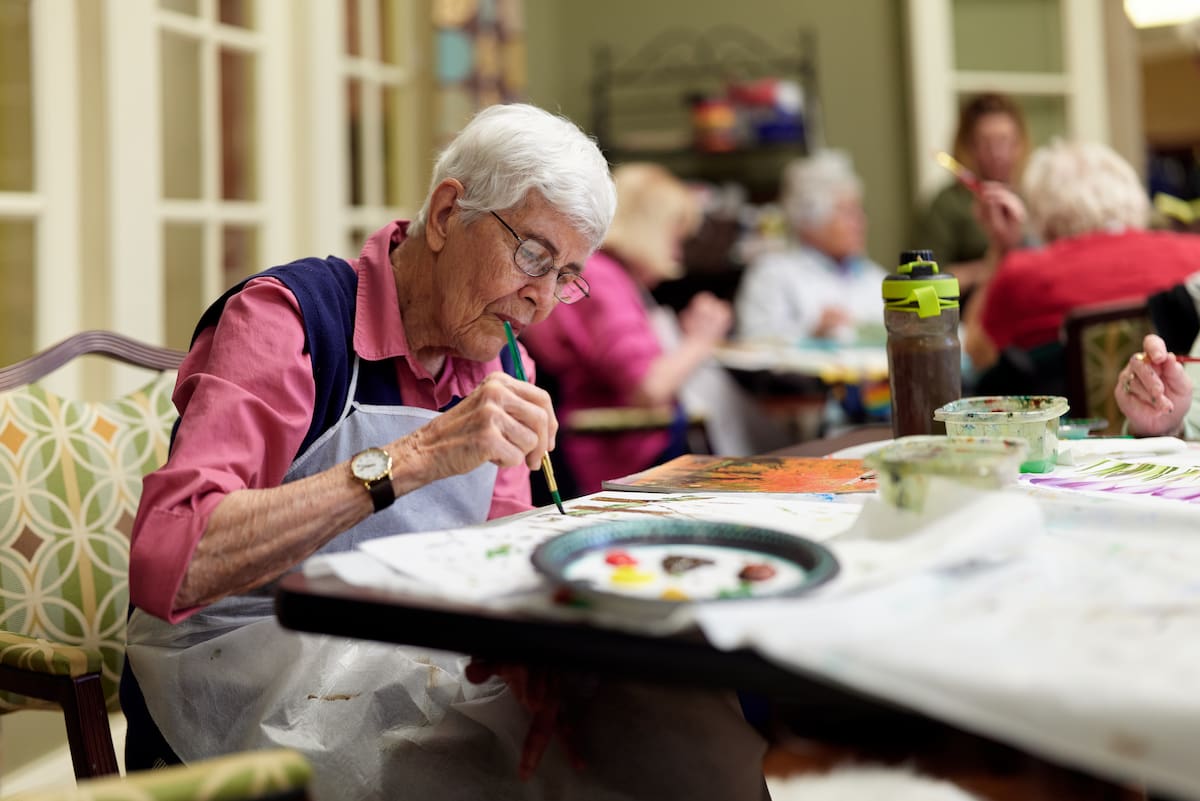 An elderly resident enjoys painting
